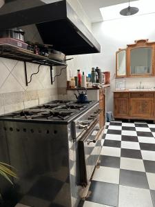 a kitchen with a stove and a checkered floor at Hostel El Puesto in San Antonio de Areco