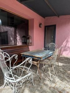 una mesa de madera y sillas en un patio en Hostel El Puesto en San Antonio de Areco