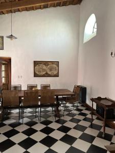 a dining room with a table and chairs on a checkered floor at Hostel El Puesto in San Antonio de Areco