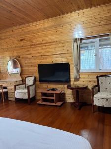 a bedroom with a television in a wooden wall at Yun Hsiang Zhan Chalet in Hualing