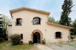 a large house with a door and windows at Can Mariné in San Antonio de Vilamajor