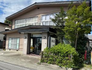 ein Gebäude mit offener Tür auf einer Straße in der Unterkunft 北アルプス麓のゲストハウス林屋 203 in Ō-shinden