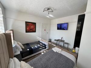 a room with a bed and a table in it at Sheri's Home away in Hither Green