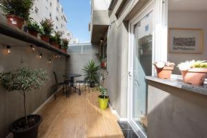 uma pequena varanda com uma mesa e vasos de plantas em L'Atelier - Warm Porto Loft em Porto