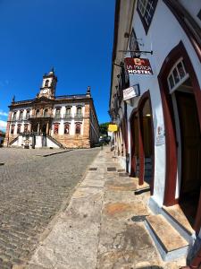 a street with a building with a clock tower at La Musica Hostel OuroPreto in Ouro Preto