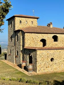 a stone building with two flower pots in front of it at Podere Montale Il Borgo in Seggiano