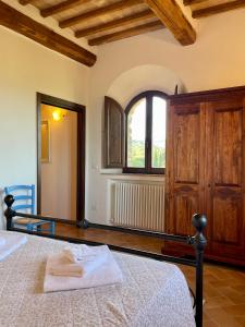 a bedroom with a bed and a large window at Podere Montale Il Borgo in Seggiano
