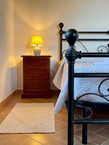 a bedroom with a bed with a lamp and a dresser at Podere Montale Il Borgo in Seggiano