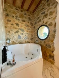 a bath tub in a bathroom with a stone wall at Podere Montale Il Borgo in Seggiano