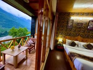 1 dormitorio con 1 cama y balcón con vistas. en Bentenwood Resort - A Beutiful Scenic Mountain & River View, en Manali