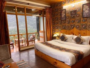 um quarto com uma cama grande e uma varanda em Bentenwood Resort - A Beutiful Scenic Mountain & River View em Manali