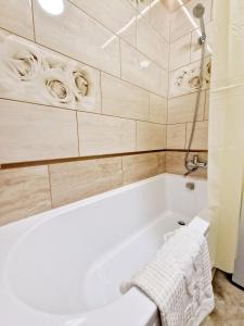 een badkamer met een wit bad en een wastafel bij Apartament on Chornovola, 40 ЖК "Варварівка" in Loetsk
