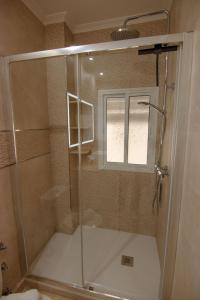 a shower with a glass door in a bathroom at RentalSevilla Centrico Apartamento junto al Guadalquivir con Parking coche mediano in Seville