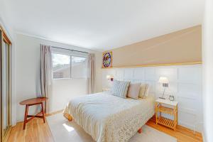 ein weißes Schlafzimmer mit einem Bett und einem Fenster in der Unterkunft Skyline Ridge in Crestline