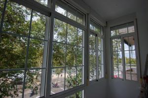a room with windows looking out at a park at RentalSevilla Centrico Apartamento junto al Guadalquivir con Parking coche mediano in Seville
