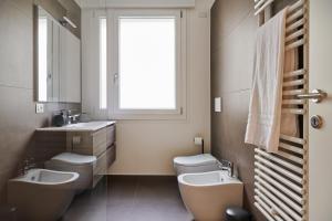 La salle de bains est pourvue de 2 lavabos, de 2 toilettes et d'une fenêtre. dans l'établissement ALLOGGIO MARGHERITA, à Trévise