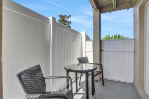 een patio met 2 stoelen, een tafel en een hek bij Islander's Outpost in Dunedin +15 foto's