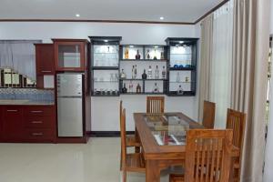 La cuisine est équipée d'une table, de chaises et d'un réfrigérateur. dans l'établissement Sri Ra'anana Villa, à Marawila