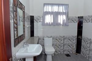 baño con lavabo y aseo y ventana en Sri Ra'anana Villa, en Marawila