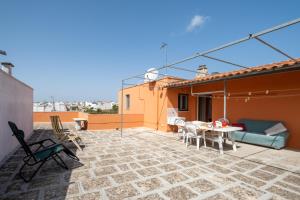 eine Terrasse mit einem Tisch und Stühlen auf dem Dach in der Unterkunft Terrazza Salentina in Tricase