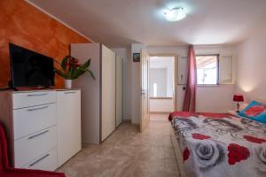 ein Schlafzimmer mit einem Bett und einem TV auf einer Kommode in der Unterkunft Terrazza Salentina in Tricase