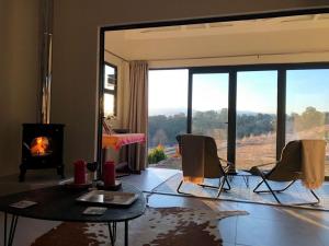 un soggiorno con camino, tavolo e sedie di Sunset View Self catering Cottage a Underberg