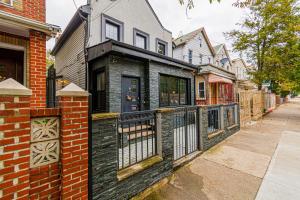 a black brick house with a gate on a street at Luxury in the Heart of Brooklyn in Brooklyn