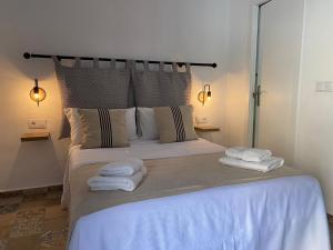 a bedroom with a large bed with towels on it at Apartamentos Makao Puerta del Olivillo in Jerez de la Frontera