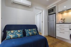uma cama azul num pequeno quarto com uma cozinha em 133 B - My lovely house in Alfama with AC em Lisboa