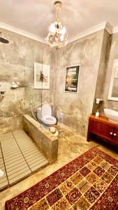 a bathroom with a tub and a toilet and a sink at Killi Luxury Villa in Moshi