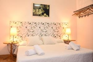 バルセロナにあるAlly's Bed&Breakfast,のベッドルーム(白い大型ベッド、ランプ2つ付)