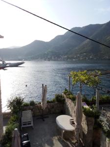 a patio with a view of the water and a boat at Apartment Aleksandar in Tivat