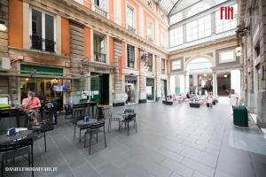 a large room with tables and chairs in a building at Mazzini House by Holiday Home 24 in Genova