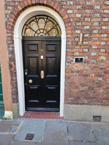 una puerta negra en el lateral de un edificio de ladrillo en Carlisle City Centre. The Annex. en Carlisle