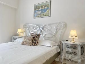 una camera con un letto bianco con due comodini di CasaViva - Family Home in Santa with AC a Santa Margherita Ligure