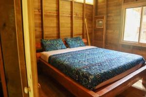 a bedroom with a bed in a wooden cabin at Jungle beach 2 bedroom cottage in Bocas Town