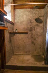 a bathroom with a shower with a shelf on the wall at Jungle beach 2 bedroom cottage in Bocas Town