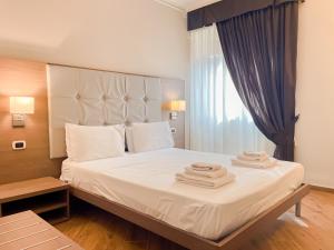 - une chambre avec un grand lit et des serviettes dans l'établissement Brain Penthouse Pagani, à Pagani
