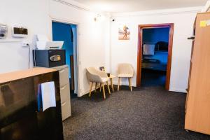 a room with two chairs and a table and a kitchen at HOSTEL SPORT BUCHAREST in Bucharest
