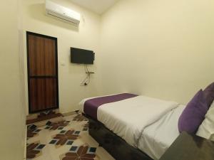a bedroom with a bed and a tv on the wall at Hotel Star of Kurla - Nearest from Kurla - Near BKC in Mumbai