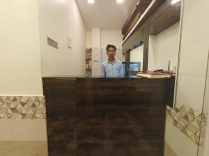 a man standing behind a counter in a room at Hotel Star of Kurla - Nearest from Kurla - Near BKC in Mumbai