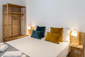 Un dormitorio con una cama blanca con almohadas amarillas y azules en BNBHolder Modern Loft I Centre, en Madrid