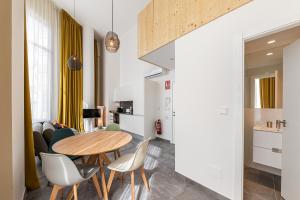 cocina y sala de estar con mesa de madera y sillas en BNBHolder Modern Loft I Centre, en Madrid