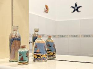 a group of four glass bottles sitting on a table at [ Portofino ] Centro di Rapallo in Rapallo +29 photos