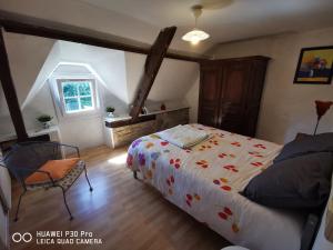 ein Schlafzimmer mit einem Bett, einem Stuhl und einem Fenster in der Unterkunft jolie longère dans un hameau de Bubry in Bubry