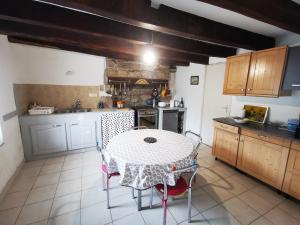 eine Küche mit einem Tisch, einem Tisch und Stühlen in der Unterkunft jolie longère dans un hameau de Bubry in Bubry