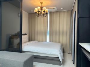 1 dormitorio con cama blanca y espejo en Ash Mellow, en Daegu