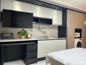 a kitchen with white cabinets and a sink at Ash Mellow in Daegu