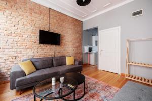a living room with a couch and a brick wall at Rustic Stone Flat 5 min to Taksim Square in Istanbul