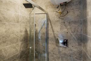 La salle de bains est pourvue d'une douche avec une porte en verre. dans l'établissement Rustic Stone Flat 5 min to Taksim Square, à Istanbul